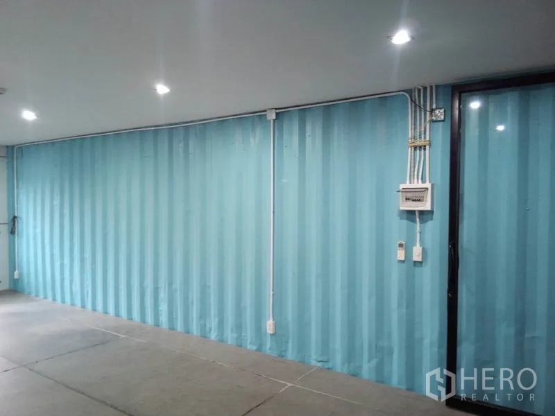 Retail Space for rent in Khlong Toei, Bangkok - Blue corrugated interior wall with exposed electrical conduits and breaker box.