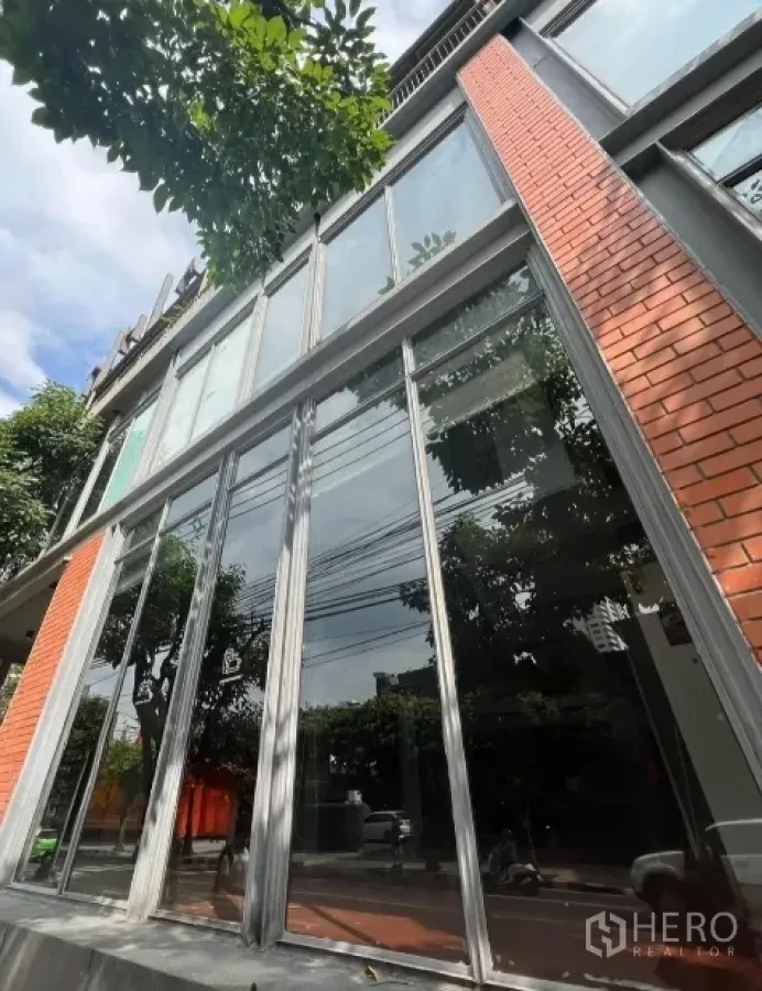Retail Space for rent in Khlong Toei, Bangkok - Modern retail building in Bangkok with tall glass facade and red brick accents.