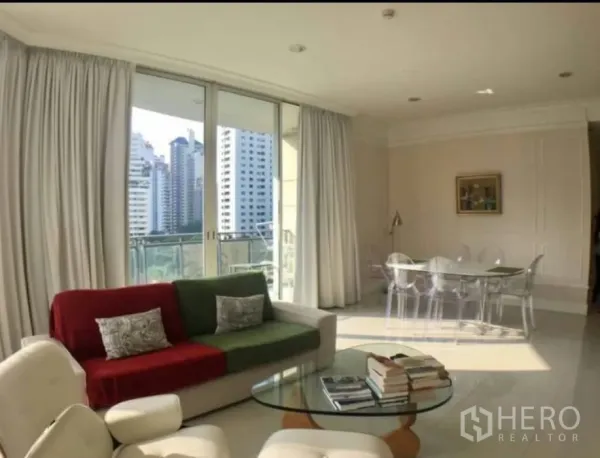 公寓 出租在Watthana, Bangkok - 客厅连接落地窗阳台，可欣赏阿索克附近的城市天际线景观。