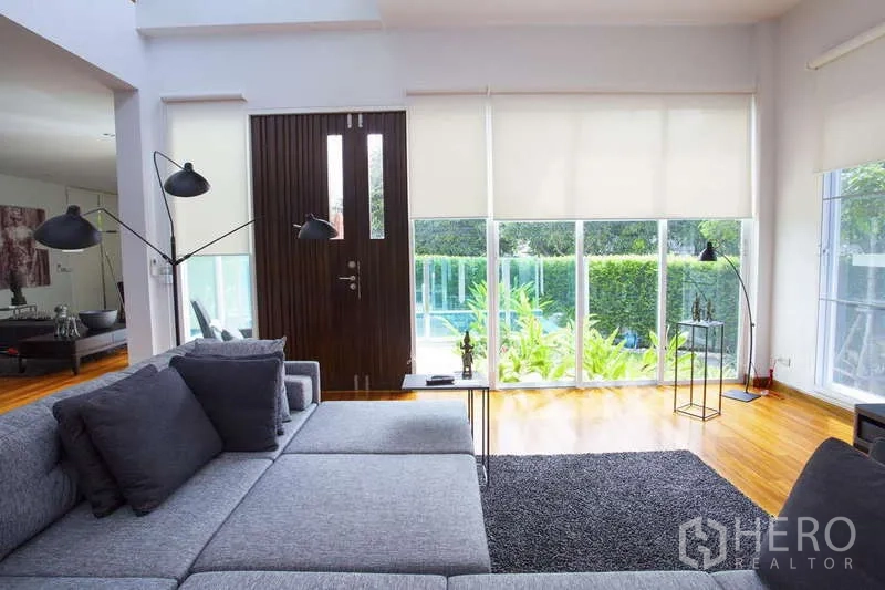 Detached House for rent in Lat Phrao, Bangkok - Living room facing the front door and glass wall opening to the pool and garden.