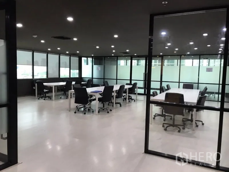 办公空间 出租在Watthana, Bangkok - 大面积玻璃隔断办公区，配置多组会议桌与座椅。
