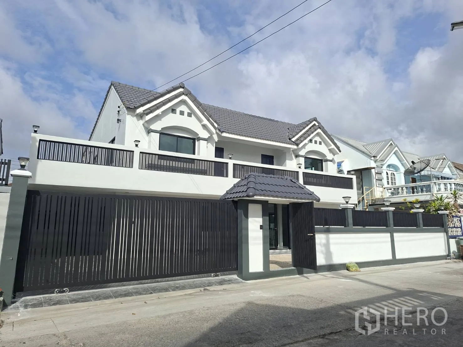 家庭办公室 for rent in Phra Khanong, Bangkok - 两层白色建筑外观，黑色高栅栏与阳台护栏。