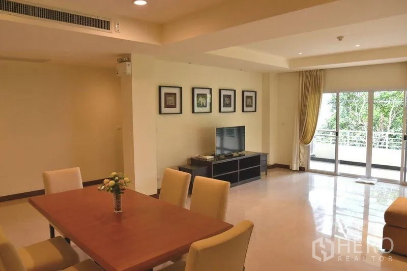 Apartment for rent in Sathon, Bangkok - Dining area adjoining living space and a wide balcony with green views.