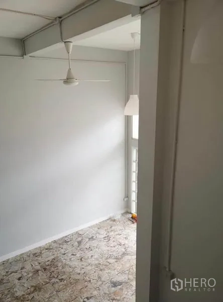 Townhouse for rent or sale in Din Daeng, Bangkok - Compact multipurpose nook with ceiling fan and terrazzo-style floor by a window.