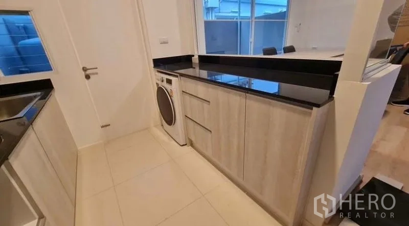 Townhouse for rent in Prawet, Bangkok - Contemporary two-storey townhouse facade with gated driveway parking.