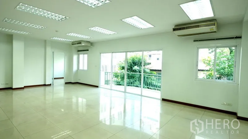 办公空间 出租在Bang Rak, Bangkok - 明亮的开放式办公室，瓷砖地面，吸顶灯，推拉门通向阳台。