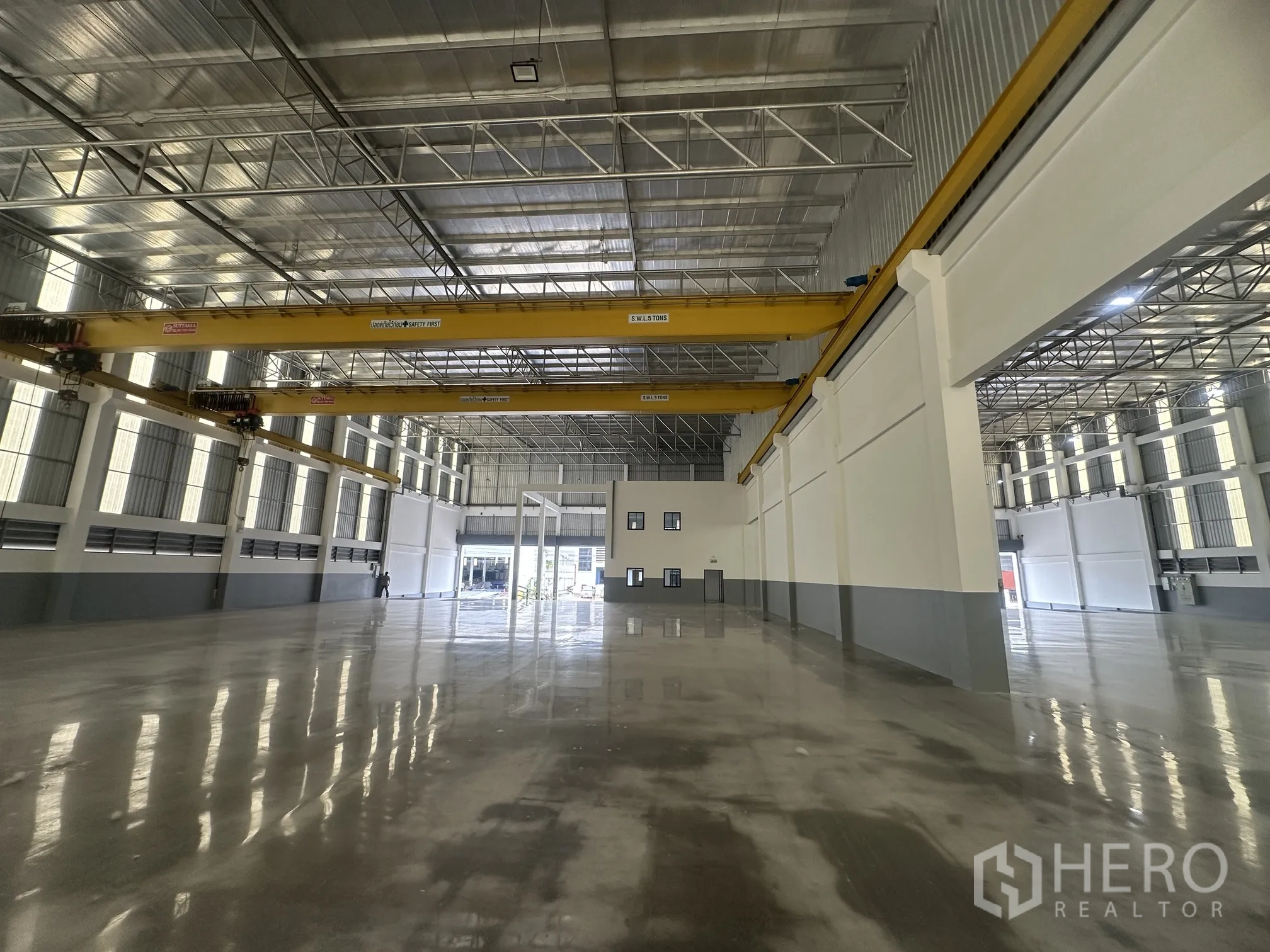 Factory for rent in Bang Phli, Samut Prakan - Wide warehouse space with cranes and open roller doors allowing truck access.