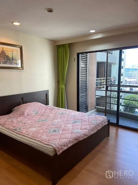 公寓 出租在Pathum Wan, Bangkok - 次卧通过推拉门通往阳台，可见城市景致。