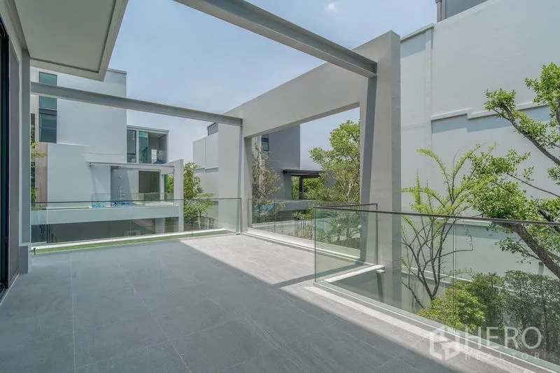 Detached House for rent - Large terrace with glass balustrade overlooking greenery and modern homes.