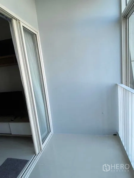 Condominium for rent in Phra Khanong, Bangkok - Bright condo balcony with white railing and sliding glass door in Phra Khanong.