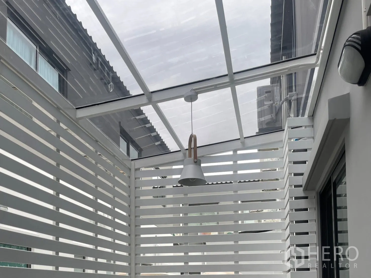 ทาวน์เฮาส์ for rent in Bang Phli, Samut Prakan - เฉลียงส่วนตัวมุงหลังคาใส ระแนงบังสายตาสีขาว และโคมแขวน