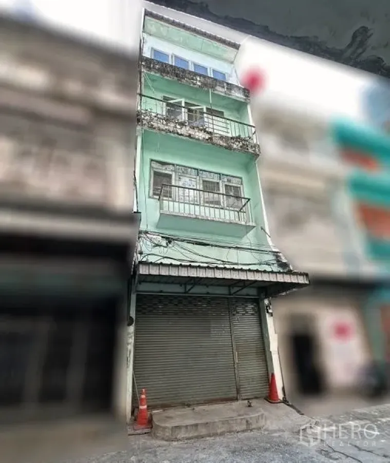 店屋 出租在Khlong Toei, Bangkok - 四层薄荷绿色店屋外立面，带阳台与卷帘门，位于小巷。