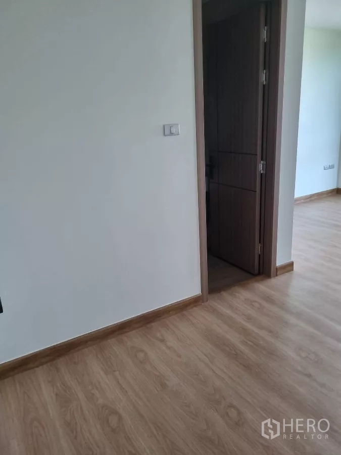 Home Office for rent in Khlong Toei, Bangkok - Interior corridor with wood floors and doorway to a room.