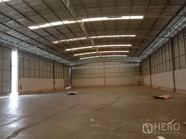 คลังสินค้า ให้เช่าในLat Krabang, Bangkok - มุมมองด้านข้างของโกดังโล่ง ประตูม้วนขนาดใหญ่และพื้นคอนกรีต