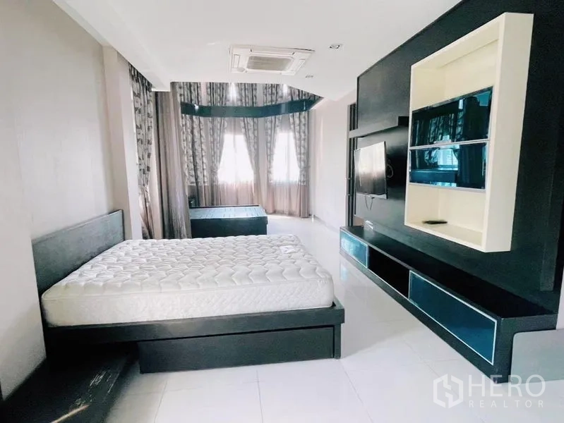 独立式住宅 出租或出售在Prawet, Bangkok - 宽敞主卧，内置媒体墙、飘窗与大床。