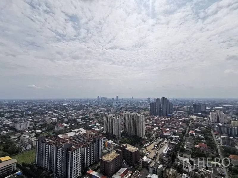 คอนโด ขายในPhra Khanong, Bangkok - วิวระเบียงชั้นสูง เห็นทิวทัศน์บางจากและพระโขนงกว้างไกลใต้ท้องฟ้ามีเมฆ