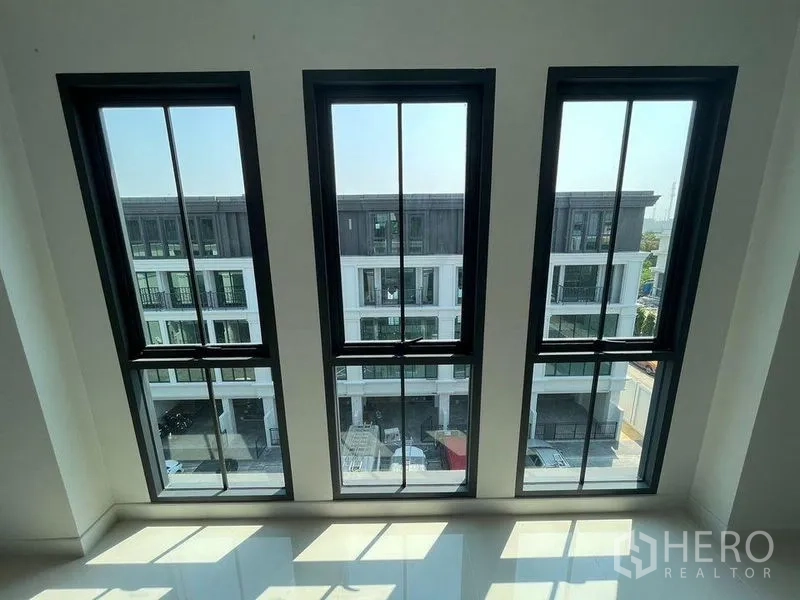 带办公室的家 出租 - 透过三扇高窗可见对面现代联排建筑景观。
