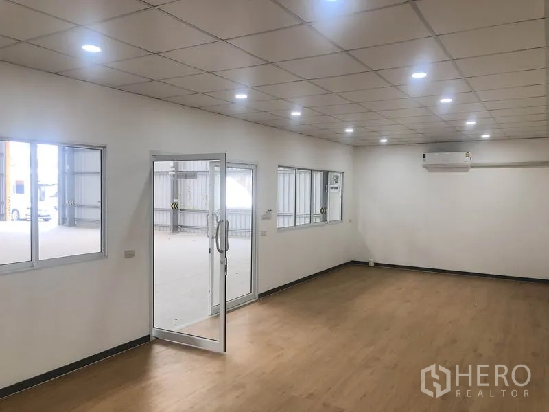 Warehouse for rent in Bang Yai, Nonthaburi - Air‑conditioned office room with LED downlights, glass door and windows overlooking the warehouse.
