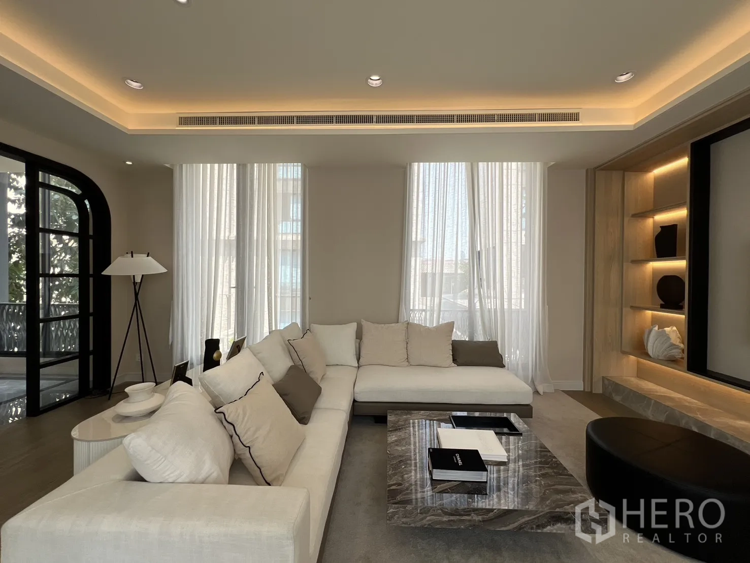 Semi-detached House for sale in Yan Nawa, Bangkok - Bright lounge with sectional sofa, sheer curtains, and recessed lighting.