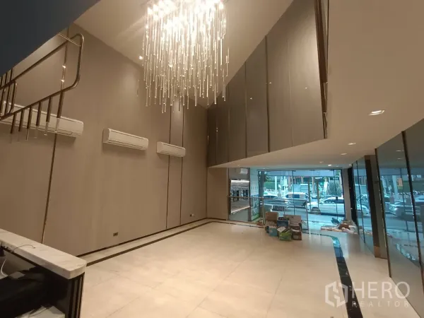 带办公室的家 出租或出售在Phra Khanong, Bangkok - 挑高大厅配水晶吊灯与大理石质感地砖，整面落地玻璃采光。