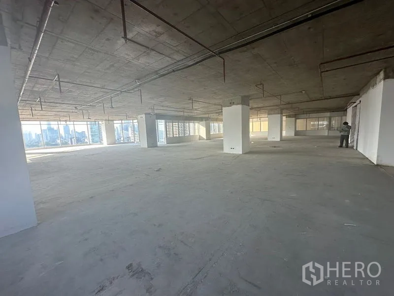 Office Space for rent in Watthana, Bangkok - Expansive unfinished office level with multiple columns, wraparound glazing and city views, ready for custom fit-out.