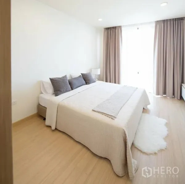 คอนโด ให้เช่าในWatthana, Bangkok - ห้องนอนที่สองมีหน้าต่างบานใหญ่ ผ้าม่านสีเบจ พรมขนฟู และพื้นไม้โทนอุ่น