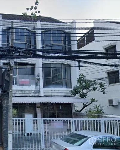 Retail Space for rent in Watthana, Bangkok - Street view of a three-storey shophouse with large bay windows and a gated frontage, power lines overhead.