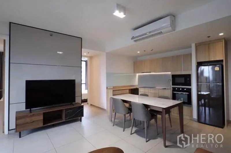 公寓 出租在Watthana, Bangkok - 客餐厅一体，电视柜、空调与全套厨房设备。