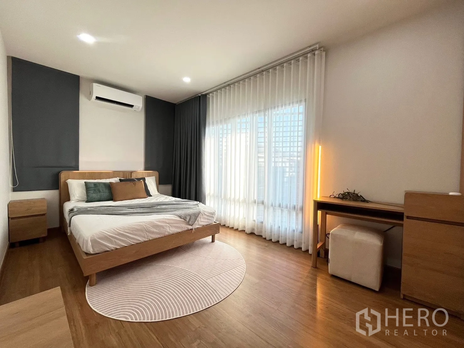 Detached House for rent in Bang Phli, Samut Prakan - Spacious master bedroom with wood bed, large windows and a work desk.