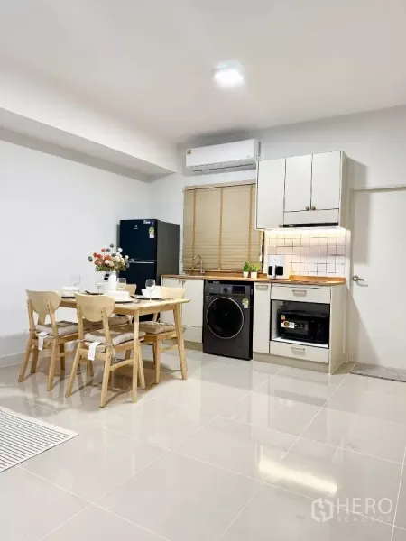 Townhouse for rent in Bang Phli, Samut Prakan - Bright kitchen and dining area with built-in cabinets, washer-dryer and refrigerator.