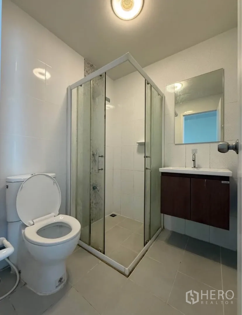 Townhouse for rent in Suan Luang, Bangkok - Modern bathroom with glass shower enclosure, vanity and toilet.