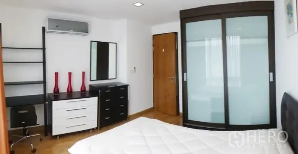 公寓 出租在Watthana, Bangkok - 卧室配书桌、抽屉柜、弧形推拉衣柜与空调。