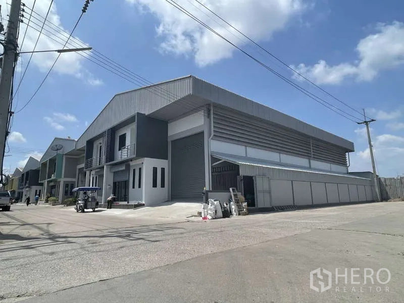 โรงงาน ให้เช่าในBan Phaeo, Samut Sakhon - มุมมองภายนอกอาคารโกดัง ประตูม้วนขนาดใหญ่ ติดถนนกว้าง.