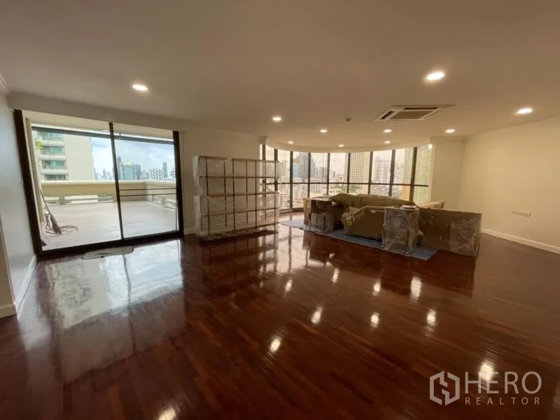 公寓 出租在Khlong Toei, Bangkok - 宽敞客厅，亮泽木地板，筒灯，落地推拉门通往大阳台，城市景观