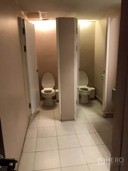 Office Space for sale in Watthana, Bangkok - Restroom area with tiled floor and multiple toilet stalls.