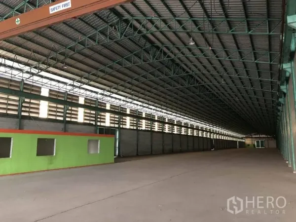 Warehouse for rent in Samut Prakan - Long, open warehouse bay with steel structure, natural light panels, and expansive floor area.