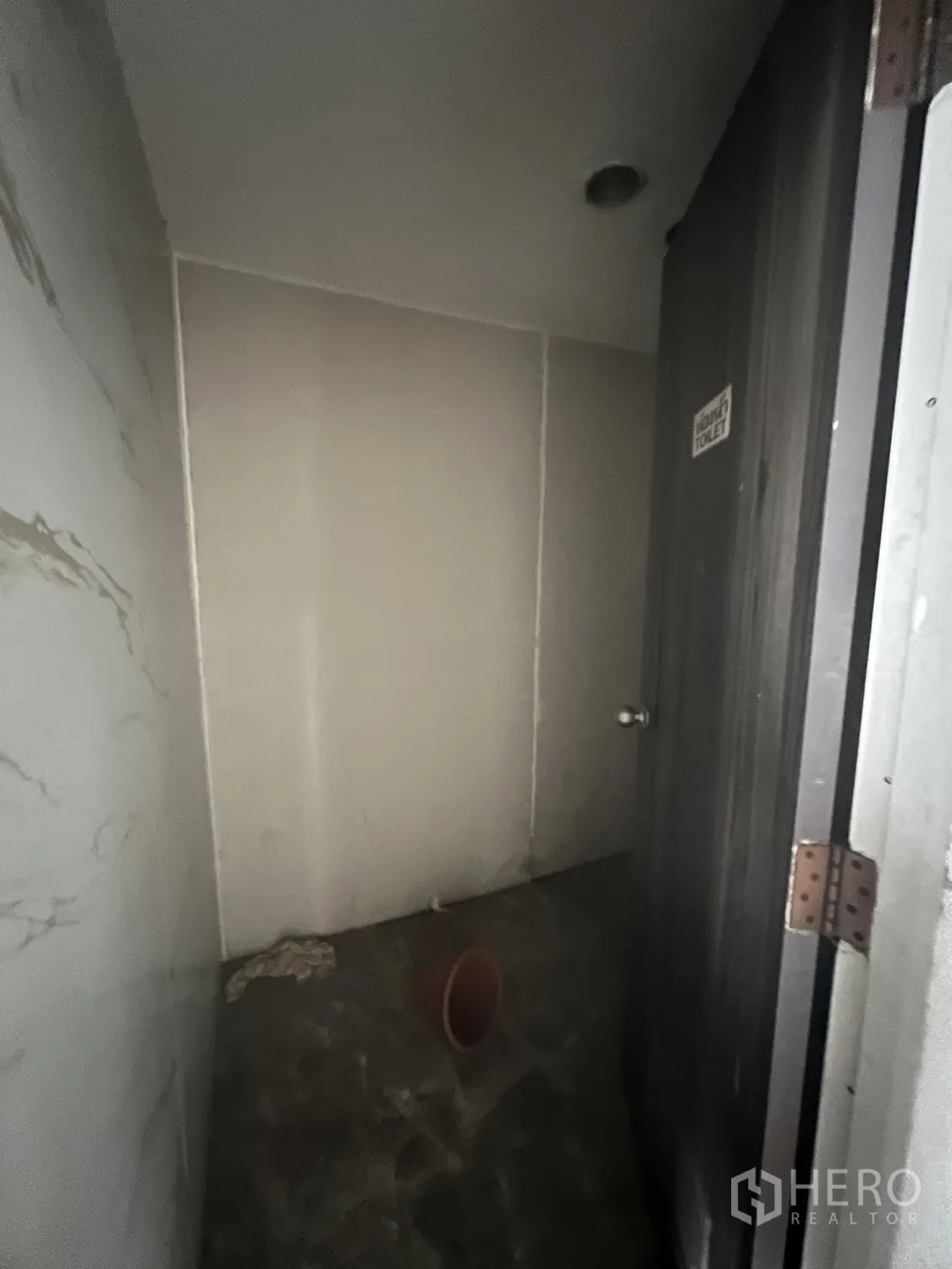 Retail Space for rent in Khlong Toei, Bangkok - Small restroom shell awaiting refurbishment with tiled walls.