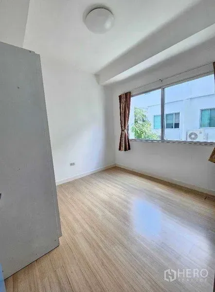 带办公室的家 出租或出售在Suan Luang, Bangkok - 采光良好的卧室，大窗与浅色木地板、白墙