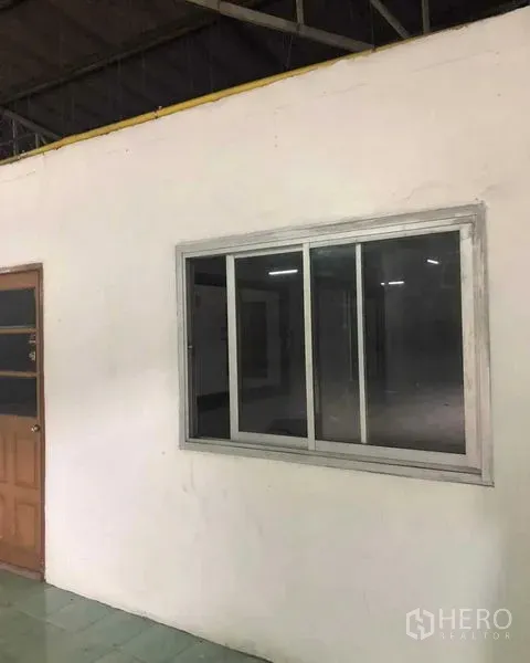 Warehouse for rent in Khan Na Yao, Bangkok - Internal office block with sliding window and wooden door inside the warehouse.