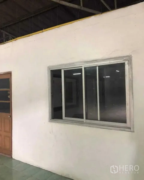 Warehouse for rent in Khan Na Yao, Bangkok - Internal office block with sliding window and wooden door inside the warehouse.