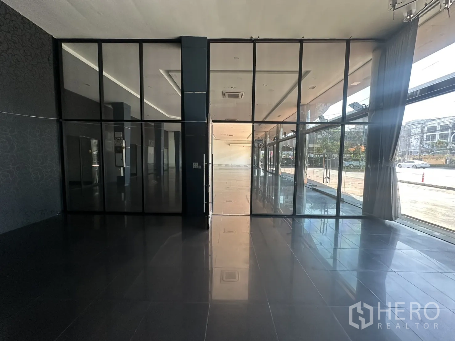 Showroom for rent in Suan Luang, Bangkok - Entrance area with full-height glass partitions and curtained windows.