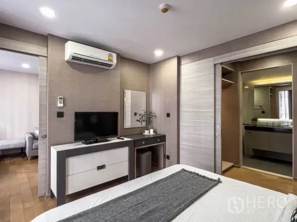 คอนโด ให้เช่าในPathum Wan, Bangkok - ห้องนอนมีทีวี โต๊ะเครื่องแป้ง และทางเข้าห้องน้ำผ่านประตูบานเลื่อน