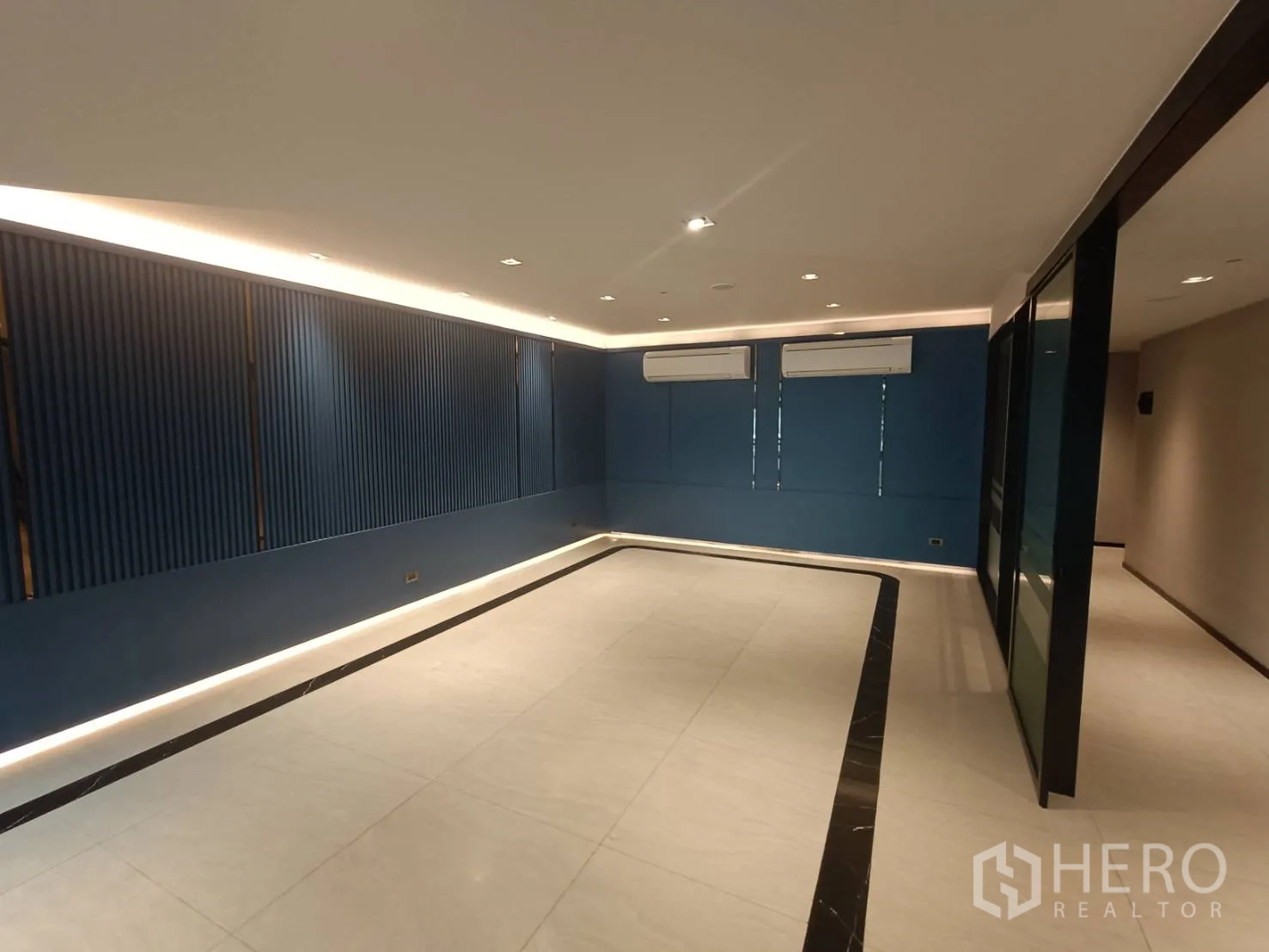 带办公室的家 出租或出售在Phra Khanong, Bangkok - 开放式大办公室，蓝色强调墙、两台空调与周界灯带。
