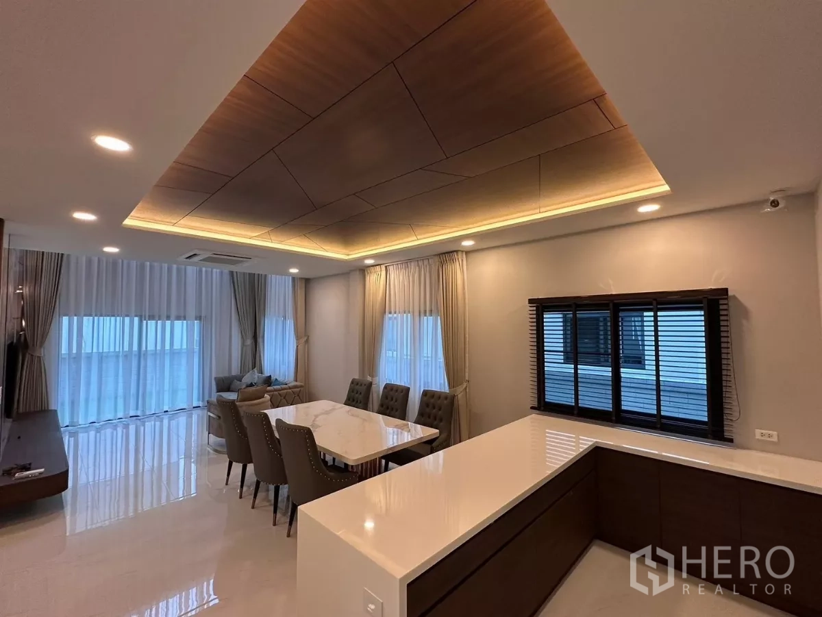 独立式住宅 出租在Bang Phli, Samut Prakan - 开放式餐厅与备餐台，木质格栅天花与暖光灯。