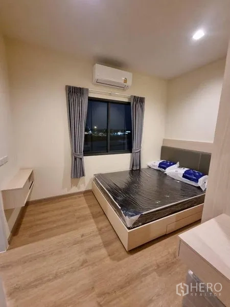 Townhouse for rent - Cozy bedroom with double bed, window views and a wall-mounted air conditioner over wood-look flooring.