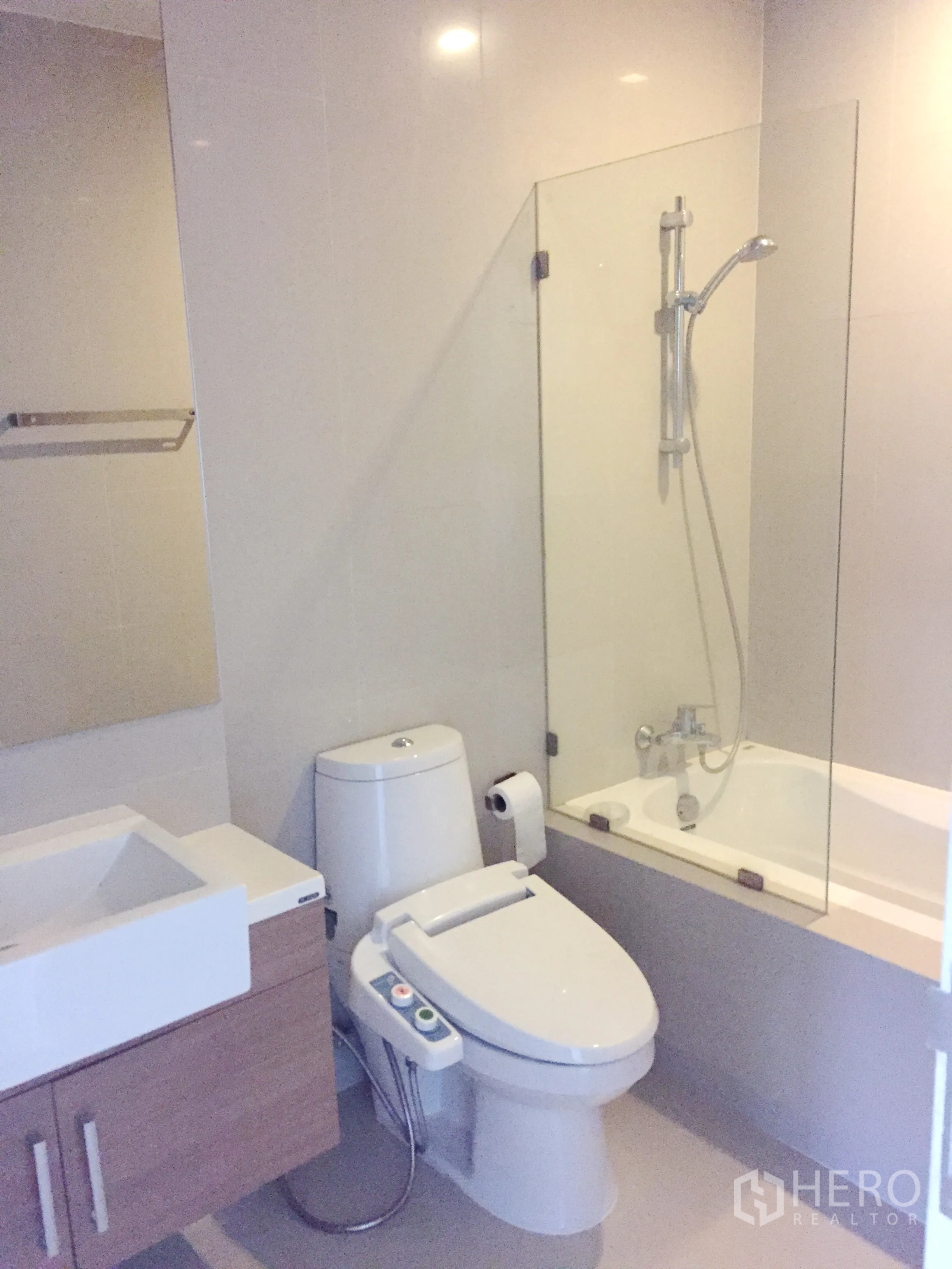 Condominium for rent in Bangkok - Modern bathroom with vanity, bidet toilet, bathtub and glass shower screen.
