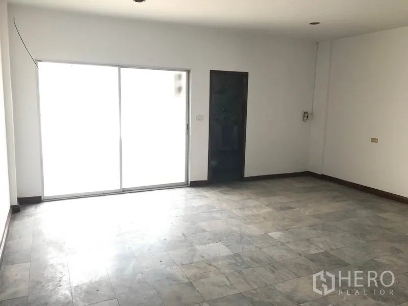 Office Space for rent in Khlong Toei, Bangkok - Bright empty office room with tiled floor and large sliding glass door.