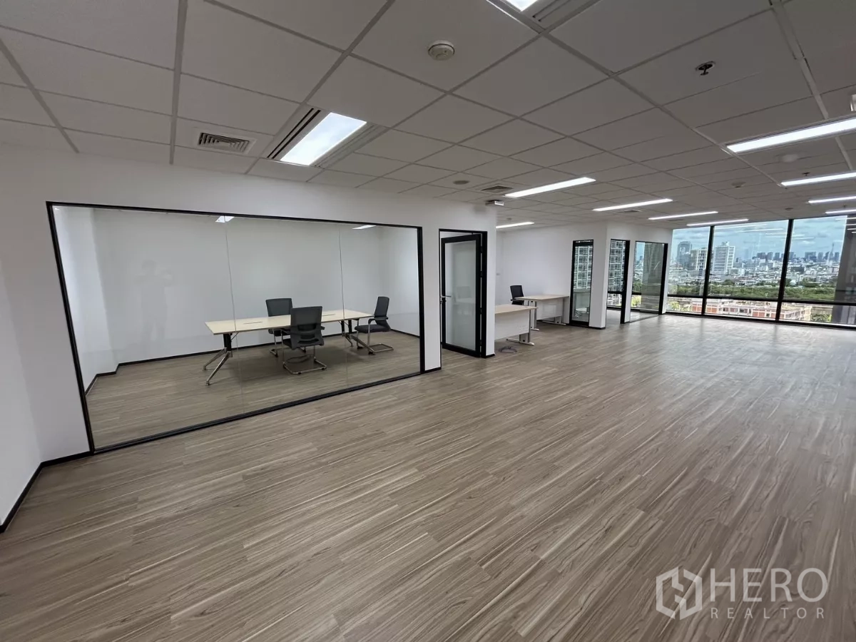 Office Space for rent - Open-plan office with a glass-walled meeting room and panoramic floor-to-ceiling windows with city views.
