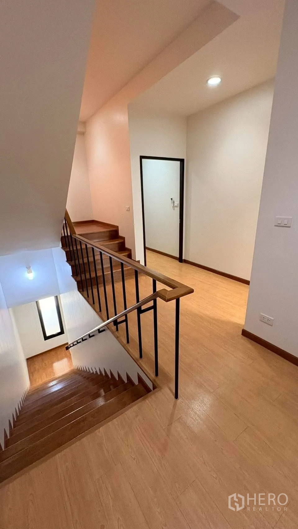 ทาวน์เฮาส์ for rent in Phra Khanong, Bangkok - บันไดไม้และโถงชั้นบนพร้อมราวเหล็กและหน้าต่าง