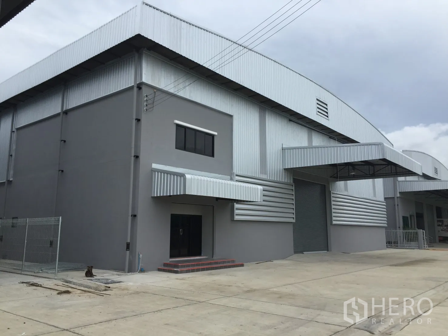 仓库 for rent in Bang Phli, Samut Prakan - 一排仓库开口，卷闸门与宽阔车道。